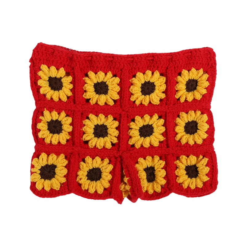 Woman wearing a red crochet dress with sunflower patterns on a beach