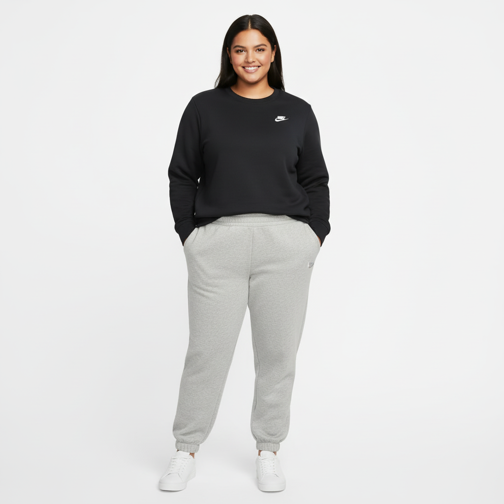 Woman wearing a black Nike sweatshirt and gray sweatpants on a white background