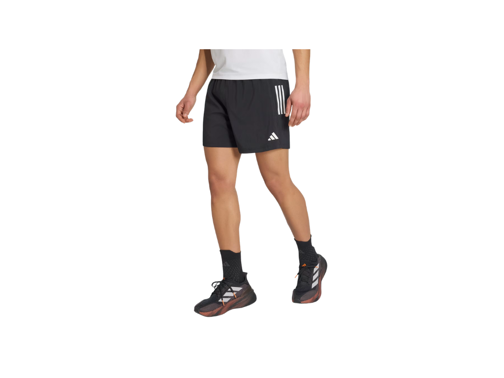 Person wearing black Adidas shorts on a white background