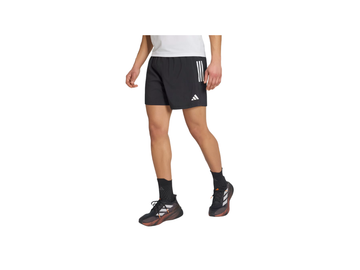 Person wearing black Adidas shorts on a white background