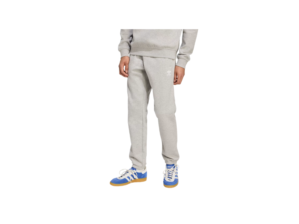 Person wearing a gray sweatshirt and pants with blue and white sneakers on a white background