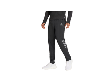 Person wearing black Adidas tracksuit with white stripes on a white background