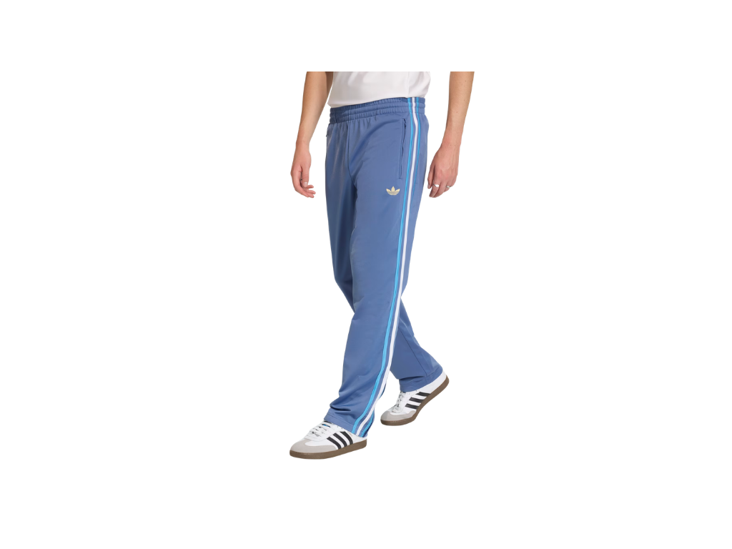 Person wearing blue Adidas tracksuit pants with white stripes on a white background