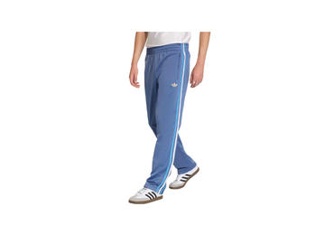 Person wearing blue Adidas tracksuit pants with white stripes on a white background