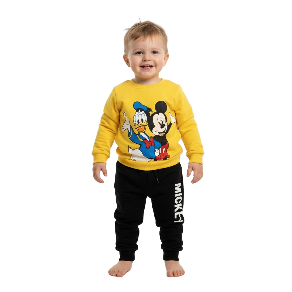Child wearing a yellow sweatshirt with cartoon characters and black pants with 'Mickey' print on a white background